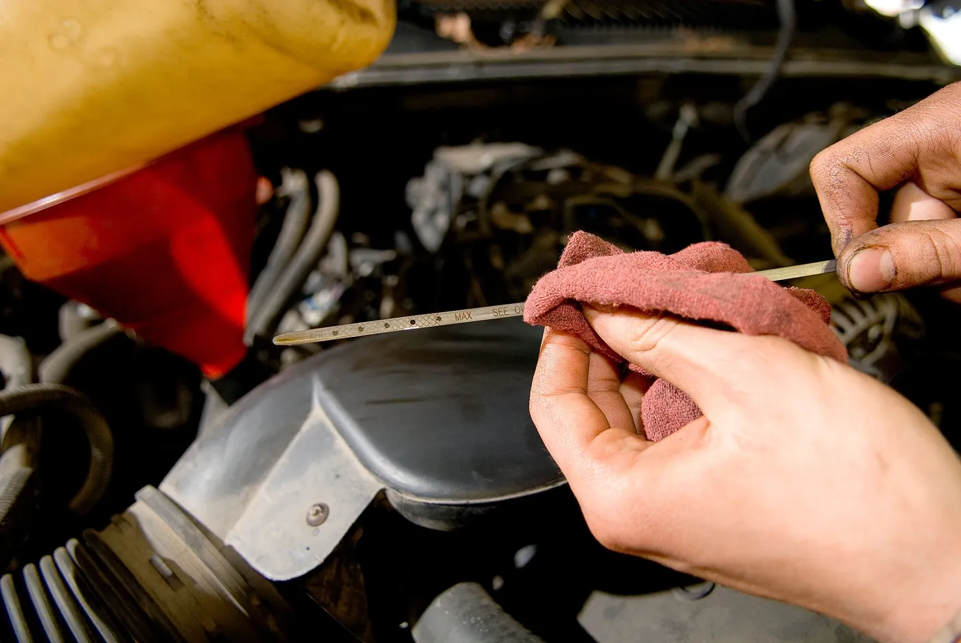 Checking the oil level on the dipstick. The grade on the bottle matters as much as the level.