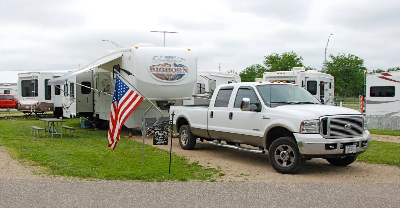 A Ford Super Duty with a fifth-wheel travel trailer at an RV rally.