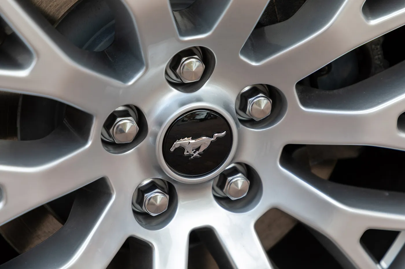A five-lug alloy wheel. With an odd number of studs, no stud sits directly across from another.